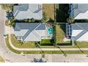 Aerial view of a backyard oasis with a sparkling pool, outdoor seating, and lush landscaping, ideal for relaxation at 6571 Simone Shores Cir, Apollo Beach, FL 33572