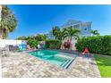 Beautiful backyard pool with colorful Adirondack chairs and lush landscaping creates a private outdoor oasis at 6571 Simone Shores Cir, Apollo Beach, FL 33572