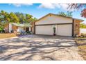 Paver driveway leads to a spacious two-car garage of this home with brick and siding accents at 7948 Floral Dr, Weeki Wachee, FL 34607