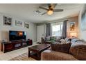 Cozy living room features a plush sofa, flat screen television, light walls, and neutral tile flooring at 8417 Moulton Dr, Port Richey, FL 34668