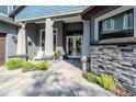 Charming front porch with seating, stylish decor, stone accents, and a welcoming double-door entrance at 9250 Rhea Dr, Odessa, FL 33556