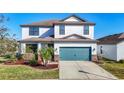 Charming two-story home features a large garage door, manicured landscaping, and a well-maintained lawn at 11846 Thicket Wood Dr, Riverview, FL 33579