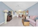 Cozy living room with tile flooring, comfortable seating, and a ceiling fan at 14130 Rosemary Ln # 3203, Largo, FL 33774