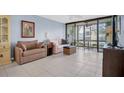Comfortable living room with tile floors, neutral-toned furniture, and access to a screened balcony at 14130 Rosemary Ln # 3203, Largo, FL 33774