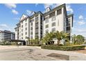 Low angle highlighting the building exterior with a circular driveway and lush, tropical landscaping at 14820 Rue De Bayonne # 205, Clearwater, FL 33762