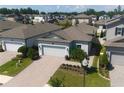 Aerial view of a home with a brick paver driveway and mature landscaping in a community with solar panels at 20092 Stone Pine Cir, Lutz, FL 33558