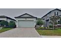 Charming single-Gathering home featuring a two-car garage and a well-manicured lawn with mature landscaping at 20092 Stone Pine Cir, Lutz, FL 33558
