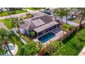 Backyard aerial view featuring a screened pool and a fenced-in backyard surrounded by tropical trees at 2031 Tanglewood Ne Way, St Petersburg, FL 33702