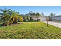 Well-maintained single-story home with a lush green lawn, mature landscaping, and a welcoming entrance at 3218 Fauna St, Sarasota, FL 34235
