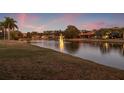 Scenic community pond with a water fountain and lush green space, perfect for outdoor enjoyment at 3830 Moreno Dr, Palm Harbor, FL 34685