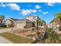 Beautifully landscaped front exterior of a two-story home featuring a well manicured lawn and a two-car garage at 5236 Clover Mist Dr, Apollo Beach, FL 33572