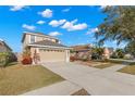 Spacious front exterior of a two-story home featuring a well manicured lawn, tasteful landscaping, and a two-car garage at 5236 Clover Mist Dr, Apollo Beach, FL 33572