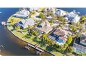 Aerial view of a waterfront home with private boat dock, lush landscaping, and inviting outdoor spaces at 5326 Loon Nest Ct, Apollo Beach, FL 33572