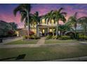 Beautiful two-story home featuring tropical landscaping, brick pathway, lush grass, and a two-car garage at 5326 Loon Nest Ct, Apollo Beach, FL 33572