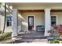 Inviting front porch featuring brick flooring, decorative columns, and a comfortable bench at 5326 Loon Nest Ct, Apollo Beach, FL 33572