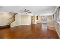 Open-concept living space with hardwood floors, stairs and ample natural light at 6262 Maisie Rd, Zephyrhills, FL 33542