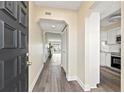 Inviting hallway with wood-look floors leading to a bright living area and modern kitchen at 716 Cordova Grn, Seminole, FL 33777