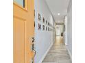 Inviting hallway with light wood floors, neutral walls decorated with framed Gathering photos, and a bright and open feel at 7403 S Obrien St, Tampa, FL 33616