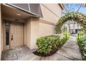 Inviting townhome entrance featuring a decorative trellis and a neutral-colored door at 846 Normandy Trace Rd, Tampa, FL 33602