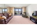 Living room with an abundance of natural light and spectacular water views from the attached balcony at 9425 Blind Pass Rd # 506, St Pete Beach, FL 33706