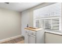 Entryway featuring tiled floors, a white storage cabinet, a window with blinds, and a white door at 952 Virginia St # 108, Dunedin, FL 34698