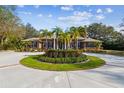 Stunning brick home boasts a circular driveway with lush palm trees and meticulously maintained landscaping at 9606 Braden Run, Bradenton, FL 34202