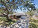 Well-maintained single-story home with a spacious driveway and mature trees at 9920 62Nd N St, Pinellas Park, FL 33782