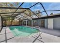 Enclosed pool with screened enclosure, tiled patio and view of the backyard at 11283 Portsmouth St, Spring Hill, FL 34609