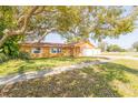 A single-story home with a well-maintained lawn and mature tree in the front yard at 11351 130Th Ave, Largo, FL 33778