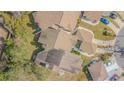 An aerial shot displaying several townhomes with a mix of beige roofs, green landscaping, and surrounding greenery at 11743 Rolling Pine Ln, Port Richey, FL 34668