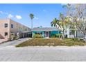 Charming, light-blue single-story home features a covered carport and verdant landscaping at 120 148Th E Ave, Madeira Beach, FL 33708