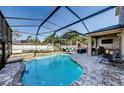 Enjoy this luxurious screened-in pool area with outdoor seating, and a covered patio with a built-in grill at 13452 Canopy Creek Dr, Tampa, FL 33625
