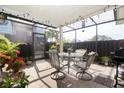 Relaxing screened lanai with dining set, grill, string lights, and lush greenery at 14511 Catalina Cir # 14511, Seminole, FL 33776