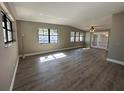 The living room offers lots of natural light, neutral paint, wood flooring, and a ceiling fan at 1501 Howard Pl, Largo, FL 33770