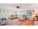 Bright living room featuring a comfortable sectional sofa, a large bay window, and modern décor at 18350 Burkholder Cir, Port Charlotte, FL 33948