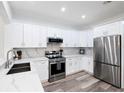 Modern kitchen featuring white cabinets, stainless steel appliances, marble backsplash, and stylish countertops at 2218 Portofino Pl # 246, Palm Harbor, FL 34683