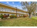 Condo building with manicured lawn and mature trees at 2280 World Parkway Blvd # 34, Clearwater, FL 33763