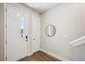 Bright entryway with wood floors, a white door, and a stylish round mirror at 2511 N Grady Ave # 41, Tampa, FL 33607