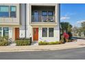 Townhouse with a charming balcony, an orange front door, and a beautifully landscaped entrance at 2511 N Grady Ave # 41, Tampa, FL 33607