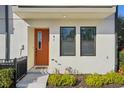 Close-up of a townhouse entry featuring an orange door and tidy, green landscaping at 2511 N Grady Ave # 41, Tampa, FL 33607