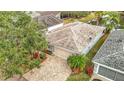 Aerial view of a well-maintained single-story home with a paver driveway and mature landscaping at 29523 Waggle Dr, San Antonio, FL 33576
