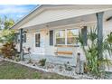 Charming front porch with seating and tropical landscaping at 3624 Wiltshire Dr, Holiday, FL 34691