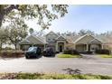 Townhome complex with mature trees and a tidy parking area and landscaping on sunny day at 3673 Kings Rd # 102, Palm Harbor, FL 34685