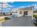 Inviting exterior with carport featuring colorful chairs and a well-maintained facade at 37150 Sandra Ave, Zephyrhills, FL 33542