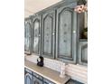 Charming blue-painted kitchen built-ins with classic hardware, offering ample storage and unique character at 4553 Kirkland Ave, Spring Hill, FL 34606