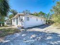 Exterior view of a bright home with a long driveway, front entry door and well-maintained landscaping at 4604 Courtland St, Tampa, FL 33610