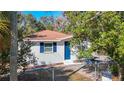 Charming house featuring a bright blue front door, complemented by white trim and a fenced front yard at 4604 Courtland St, Tampa, FL 33610