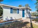 Charming home showcasing a bright blue front door, complemented by white trim and lovely brick pathway at 4604 Courtland St, Tampa, FL 33610