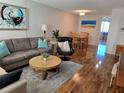 Cozy living room with sofa, chair, wood floors, table and paintings at 4915 Bay Ne St # 322, St Petersburg, FL 33703