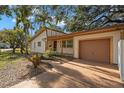 Inviting single-story home with attached garage, mature trees, and a well-manicured lawn and landscape at 4926 Camellia S Way, St Petersburg, FL 33705